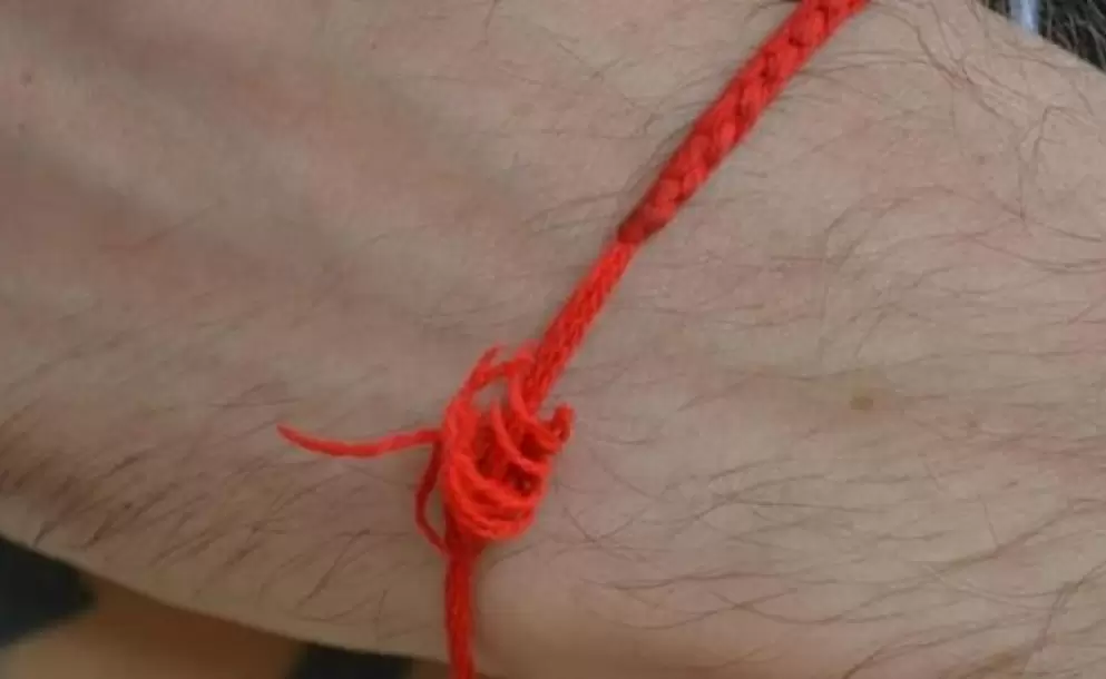 Завязанные нитки на руке. Красная нитка на руке. Оберег из ниток на запястье. Завязать нитку на запястье.