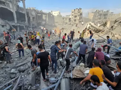 Civiles palestinos buscan víctimas entre los escombros que quedaron tras el bombardeo israelí en un centro de refugiados.