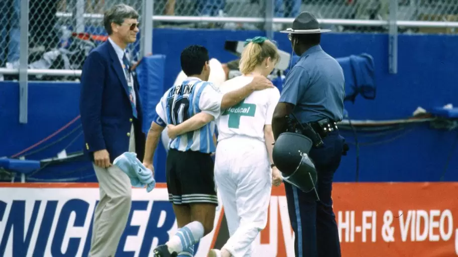 Diego Maradona retirándose del campo del juego junto a la enfermera.