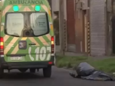 La ambulancia y el cuerpo del adolescente de 17 aos en el piso.