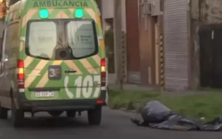 La ambulancia y el cuerpo del adolescente de 17 años en el piso.