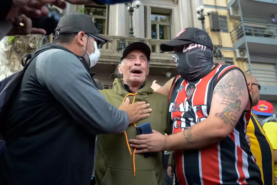 Jubilado es consolado por un hincha y por un ciudadano minutos antes de la brutal represin de las Fuerzas Armadas