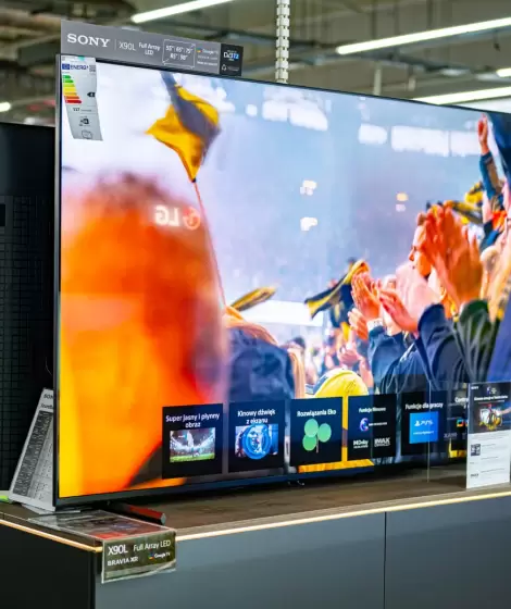 Comparativa de televisores QLED y OLED en una tienda de electrónica.