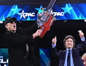 Elon Musk ostenta la motosierra que Javier Milei subió a darle al escenario.