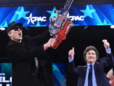 Elon Musk ostenta la motosierra que Javier Milei subió a darle al escenario.