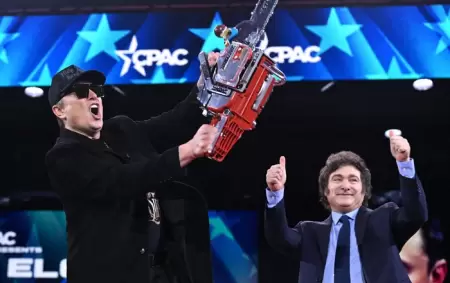 Elon Musk ostenta la motosierra que Javier Milei subió a darle al escenario.