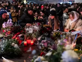 Decenas de j�venes y familias se congregaron frente a las ruinas humeantes de Le Constellation para rendir homenaje a las v�ctimas