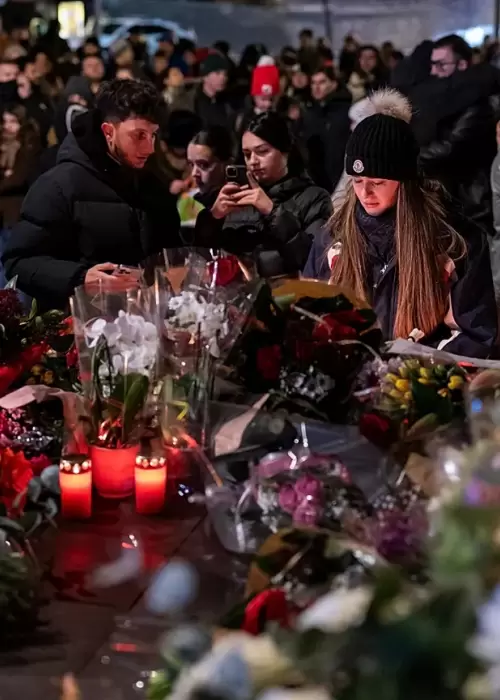 Decenas de j�venes y familias se congregaron frente a las ruinas humeantes de Le Constellation para rendir homenaje a las v�ctimas