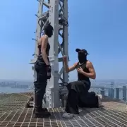 Amor al límite: escaló la cima del Empire State con su pareja, le popuso casamiento en la cima y desplegaron una bandera por la paz