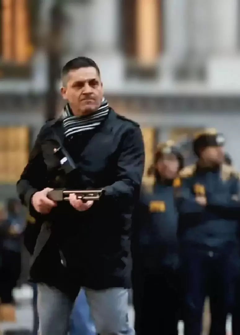Gustavo Gauna vestido de civil y disparando en las inmediaciones del Congreso